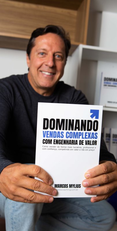 Marcos Mylius segurando um exemplar de seu livro Dominando Vendas Complexas