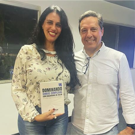 Leitora segurando o livro Dominando Vendas Complexas ao lado de Marcos Mylius