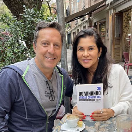 Leitora segurando o livro Dominando Vendas Complexas ao lado de Marcos Mylius