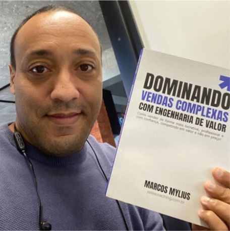 Leitor segurando o livro Dominando Vendas Complexas