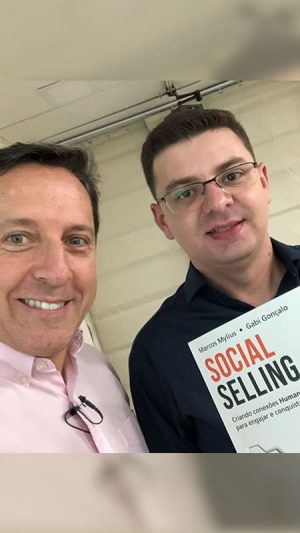 Leitor segurando o livro Social Selling ao lado de Marcos Mylius
